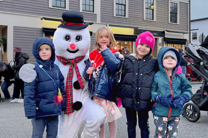 Georg Ove Andersen Mathiesen, Eva Margrethe Andersen Mathiesen, and Iris and Elliot Cameron make friends with Frosty the Snowman in downtown Concord Sunday. See a photo spread of the tree lighting festivities
